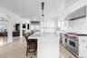 Kitchen featuring white cabinetry, a breakfast bar, high end appliances, an island with sink, and wood ceiling