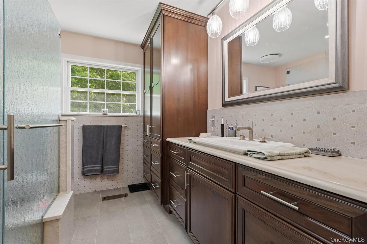 Bathroom with wood-finish cabinetry and a light countertop