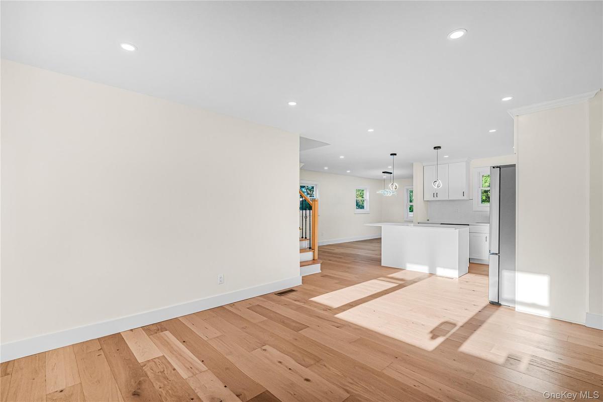 Light wood-finish flooring extending into an open-concept area with recessed lighting