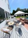 Wooden terrace with outdoor dining space and a patio