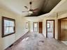 6 - Empty room with lofted ceiling, visible vents, a ceiling fan, and light colored carpet