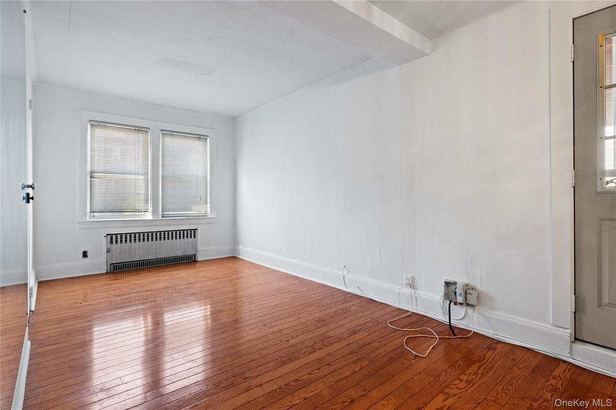 Spare room with radiator and hardwood / wood-style floors