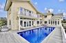 Back of property featuring french doors, stucco siding, a balcony, and a chimney