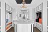 Walk in closet with a chandelier and dark wood-style floors