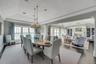 Dining area featuring a lit fireplace, a tray ceiling, crown molding, and plenty of natural light