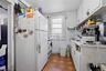Kitchen featuring white appliances, light countertops, white cabinetry, and light floors