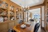 Dining space with a chandelier, arched walkways, a water view, and dark wood-type flooring