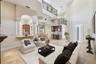 The 2 story high Family room has a gas fireplace and built in cabinetry flowing into the kitchen and dining rooms or to the outside pool and patio.