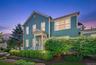 A beautiful twilight view highlights the home’s classic architecture, welcoming front entry, glowing windows, and mature landscaping.