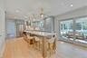 Kitchen featuring hanging light fixtures, high quality fridge, gray cabinets, light wood finished floors, and recessed lighting
