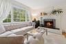 Living area with a fireplace, ornamental molding, and wood finished floors