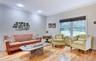 Legal accessory apartment: Bright living space featuring hardwood flooring, crown molding, recessed lighting, and a large window