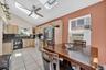 Kitchen with light brown cabinets, a skylight, light tile patterned floors, white appliances, and high vaulted ceiling
