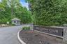 Entry sign "The Colony Club A Private Community" with stone pillars and mature evergreen landscaping