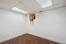 Room featuring wood-finish plank flooring, white baseboards, and a drop ceiling with recessed lighting panels