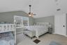 Bedroom featuring light carpet, vaulted ceiling, and a ceiling fan