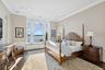 Bedroom with a wainscoted wall, ornamental molding, a water view, a decorative wall, and recessed lighting