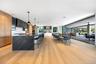 Kitchen featuring modern cabinets, a breakfast bar, healthy amount of natural light, a large island, and a wall of windows