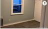 Unfurnished room featuring baseboards and dark wood-type flooring