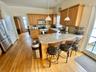 Kitchen with hanging light fixtures, stainless steel appliances, backsplash, kitchen peninsula, and a breakfast bar area