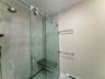 Full bathroom featuring a stall shower, a baseboard radiator, and tile patterned floors