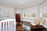 Bedroom featuring a nursery area, radiator, a closet, and dark wood-style floors