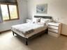 Bedroom with baseboards and light carpet
