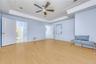 Master Bedroom featuring a ceiling fan, light wood-style flooring, a tray ceiling, and ornamental molding
