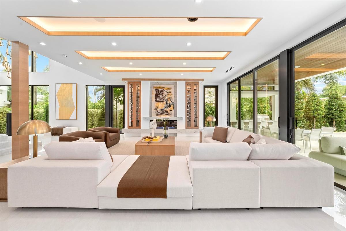 A beautifully designed formal living area with soaring ceilings, expansive windows, and stunning waterway views. The open layout seamlessly connects t