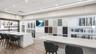 Kitchen with a kitchen breakfast bar, white cabinets, recessed lighting, and light stone counters