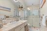 Full bathroom featuring toilet, tile walls, vanity, and a stall shower
