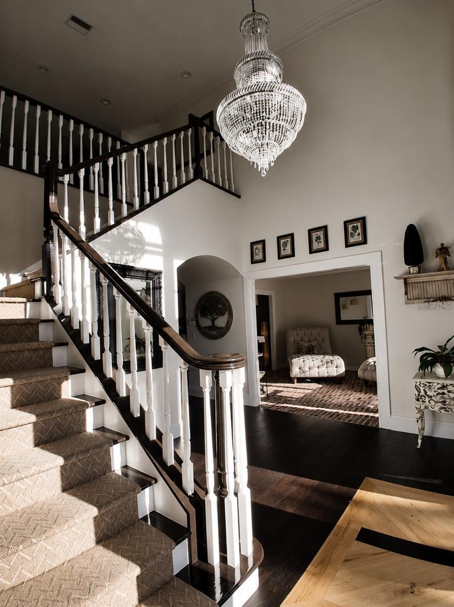 Walk into an Elegant Foyer with New Large Crystal Chandleir, Custom Stair carpet and New Hardwoods and New Front Foor