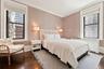 Room featuring dark wood-finish flooring, textured wall covering, and crown molding