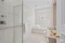 Bathroom featuring a glass-enclosed shower, built-in soaking tub, vanity with integrated sink, recessed lighting, and a window with blinds