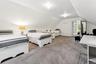 Bedroom featuring light carpet and lofted ceiling