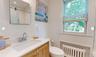 Bathroom featuring radiator, tile walls, vanity, walk in shower, and toilet