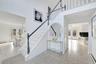 Stairway with a baseboard heating unit, tile patterned flooring, and a towering ceiling
