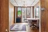 Dining room with radiator heating unit, wooden walls, a chandelier, a paneled ceiling, and wood finished floors