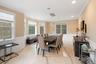 Dining space featuring light marble finish floors, a wainscoted wall, a decorative wall, crown molding, and a chandelier