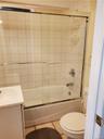 Bathroom featuring toilet, tile patterned floors, combined bath / shower with glass door, and vanity