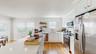 Kitchen with a sink, white cabinets, appliances with stainless steel finishes, and a healthy amount of sunlight