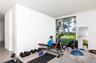 Workout area with a wall of windows and light tile patterned flooring
