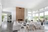 Living room with a large fireplace, a high ceiling, and concrete floors