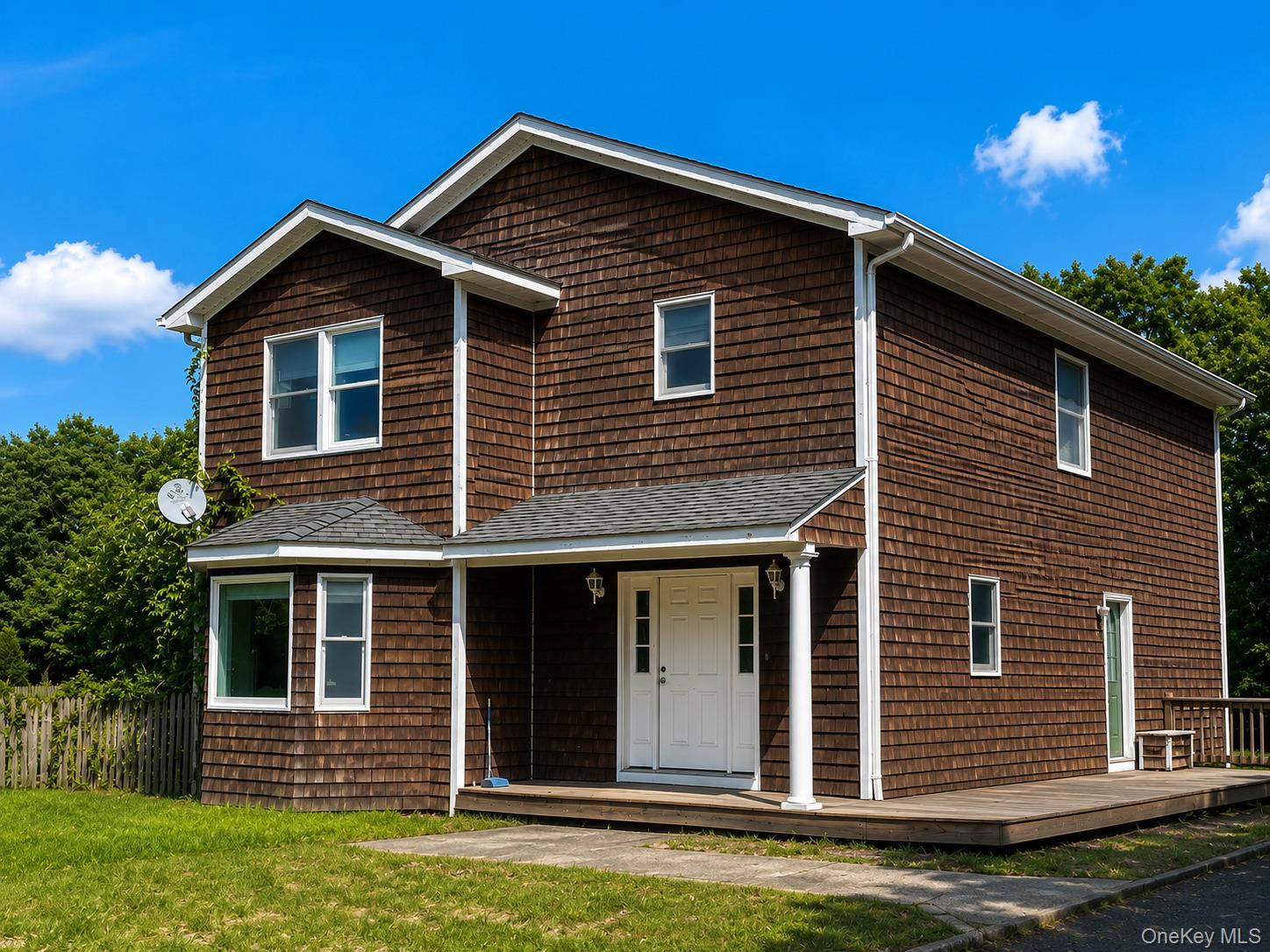 Two-story residence featuring cedar shake siding, a bay window, and a covered entry porch ( Ai enhanced)