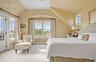 Carpeted bedroom featuring baseboards, ceiling fan, vaulted ceiling, and wallpapered walls