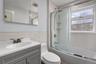 Bathroom featuring a single vanity with a gray cabinet, white countertop, and integrated sink