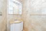 Half bathroom with vanity and tile walls