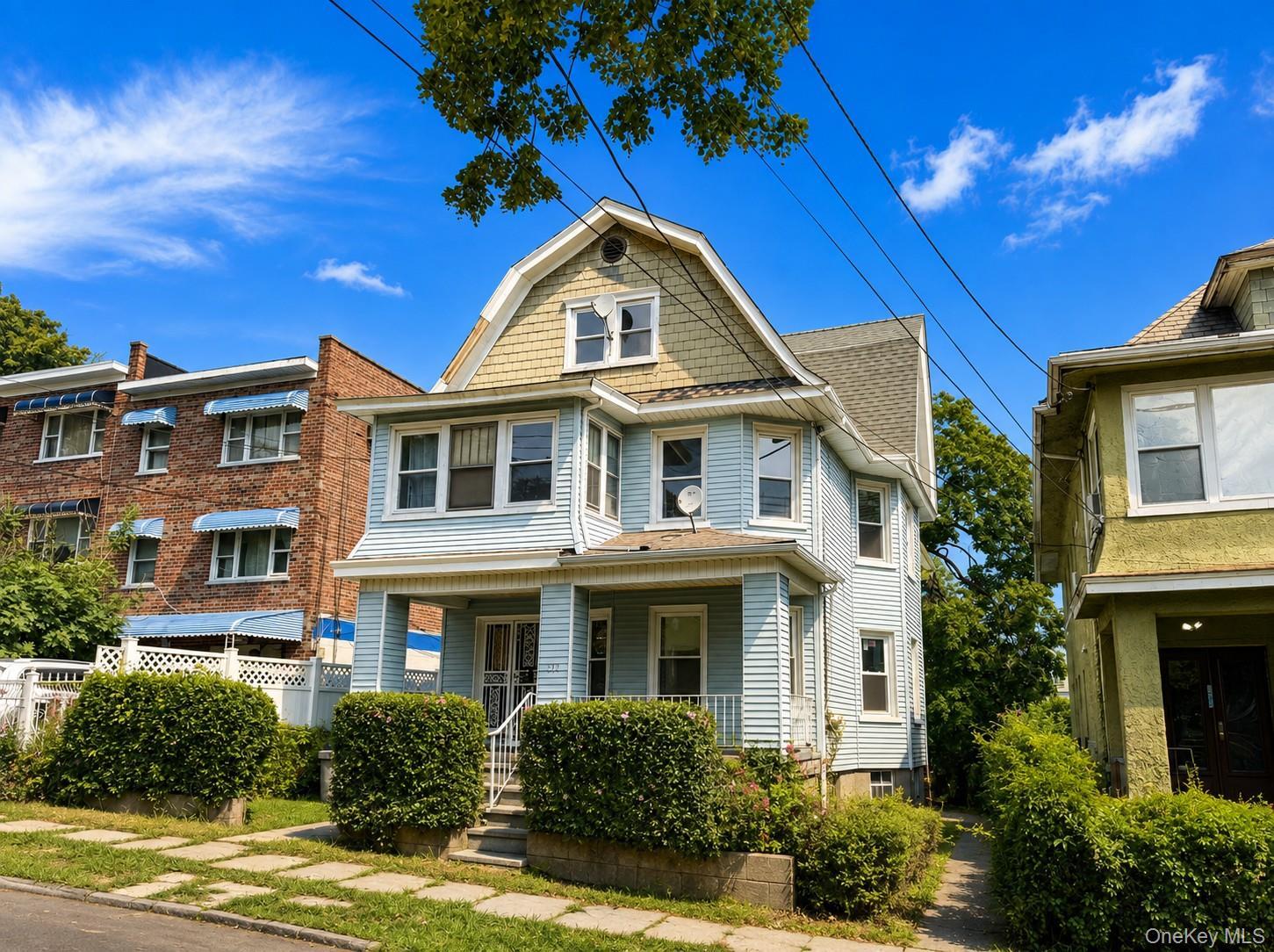 Light blue siding exterior with a gambrel roof and front porch