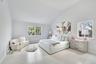 Bedroom featuring wood finished floors, baseboard heating, and high vaulted ceiling