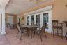 THE SPACIOUS SCREENED PORCH HAS NUMEROUS AREAS FOR SOCIALIZING